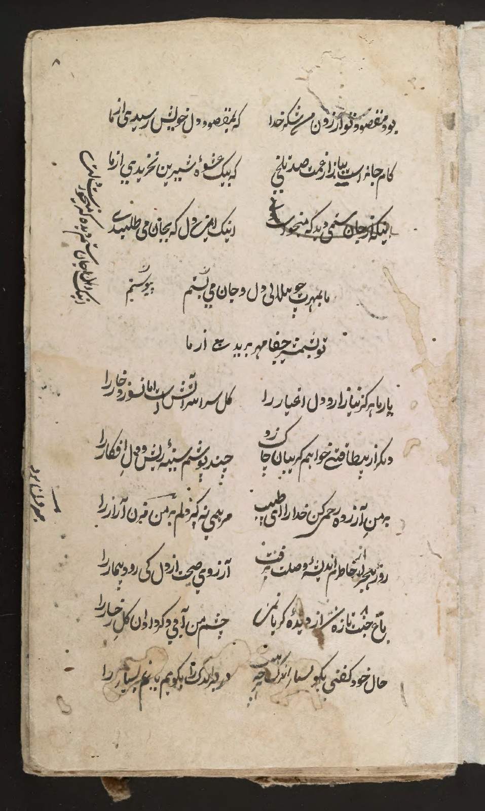 Vertical writing runs along the left edge of the verse, while a line near the top is heavily overwritten.